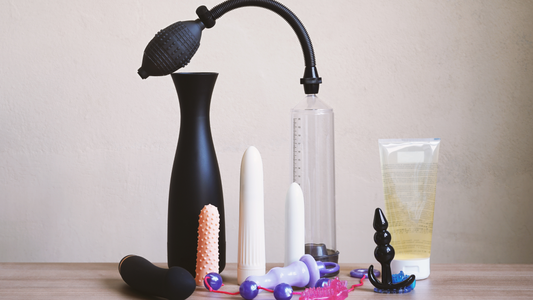 Best sex toys for men 2025 including a variety of male pleasure products such as a penis pump, vibrators, realistic strokers, anal beads, butt plugs, and lubricant, all displayed on a wooden surface.