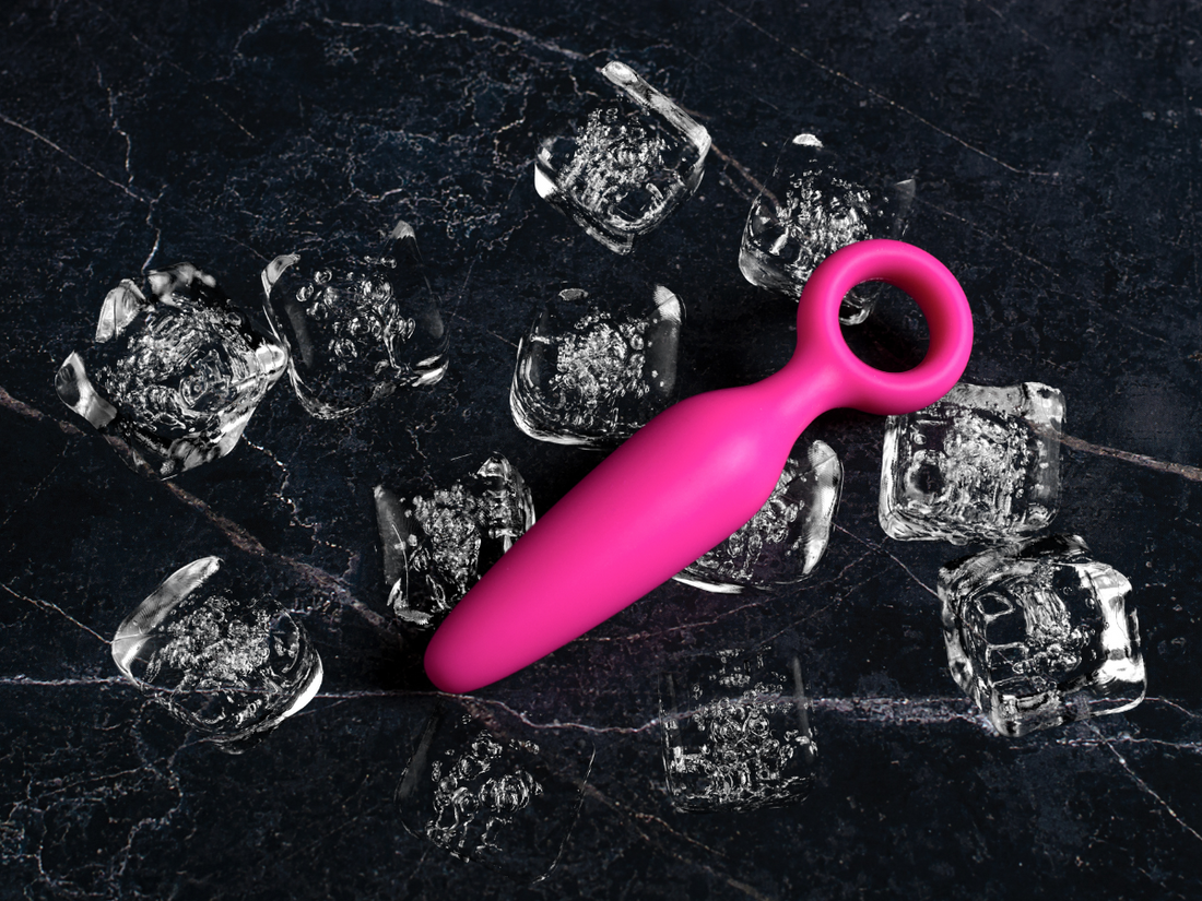 Dildo chilled on ice cubes for temperature play and sensation exploration.